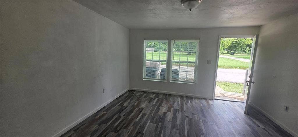 3510 Marshall Street, Greenville, TX 75401 Interior space featuring wood-finish flooring, dual-pane windows with grid detailing, and a flush-mount ceiling light fixture