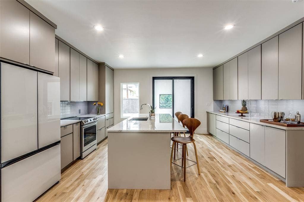 Kitchen featuring floor-to-ceiling cabinetry, a central island with a stone-surface countertop, wood-finish flooring, recessed lighting, and a stainless steel slide-in range