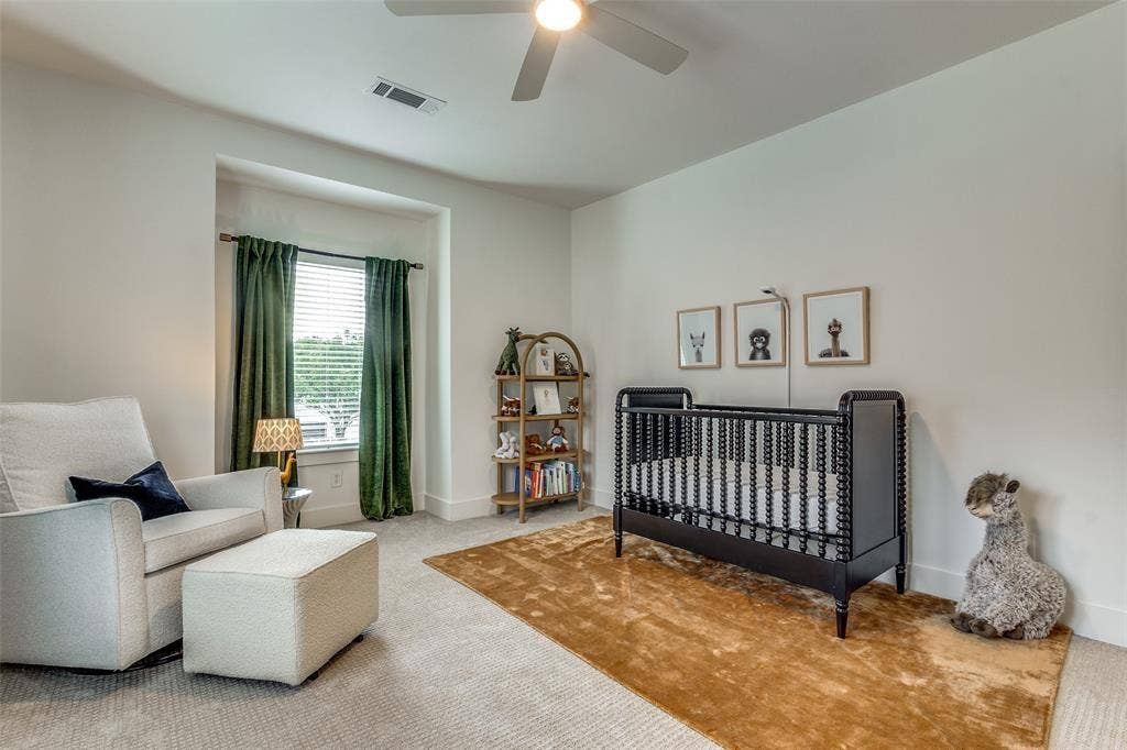 Neutral-toned interior featuring wall-to-wall carpeting, recessed window nook, and integrated ceiling fan with lighting