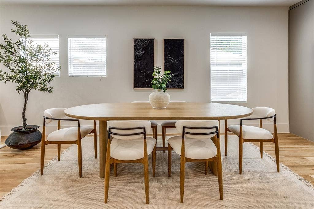 Bright room featuring wood-finish flooring, three windows with horizontal blinds, and smooth-finish neutral walls