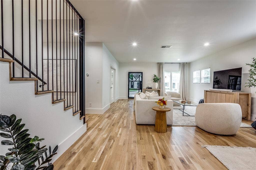 Interior space featuring wood-finish flooring, recessed lighting, and a staircase with vertical iron balusters