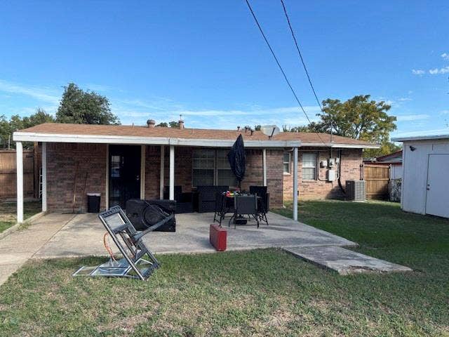 Brick exterior with a covered rear patio and a detached storage structure