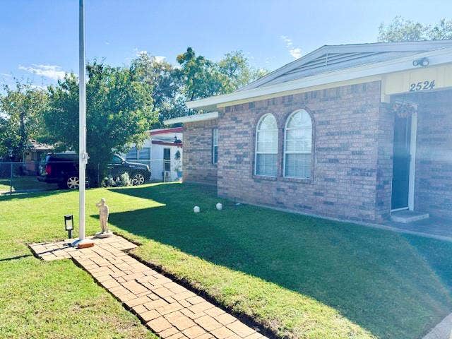 Brick exterior with paver stone walkway leading to flagpole