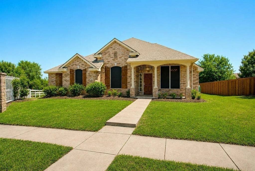 4402 Horizon Drive, Garland, TX 75043 Brick exterior featuring decorative shutters, a covered front porch with columns, and a concrete walkway