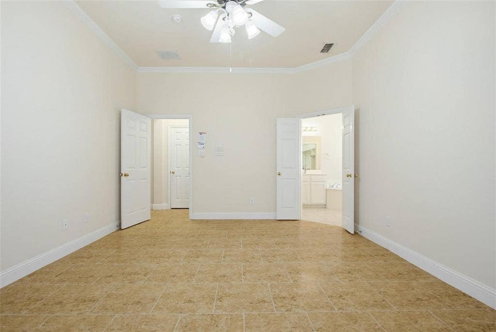 4402 Horizon Drive, Garland, TX 75043 Neutral-toned ceramic tile flooring, vaulted ceilings with crown molding, and a central ceiling fan with multi-light fixture