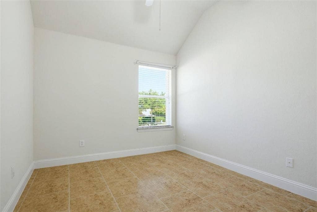 4402 Horizon Drive, Garland, TX 75043 Room featuring a vaulted ceiling, neutral wall finishes, tile flooring, and a window with horizontal blinds