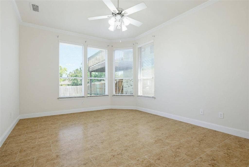 4402 Horizon Drive, Garland, TX 75043 Bay window featuring four expansive windows, neutral tile flooring, white crown molding, and a central ceiling fan with integrated lighting