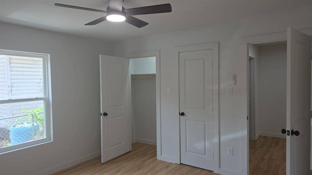 4643 Luzon Street, Dallas, TX 75216 Neutral interior space featuring wood-finish flooring, a ceiling fan with integrated lighting, multi-panel doors, and a reach-in closet with built-in shelving
