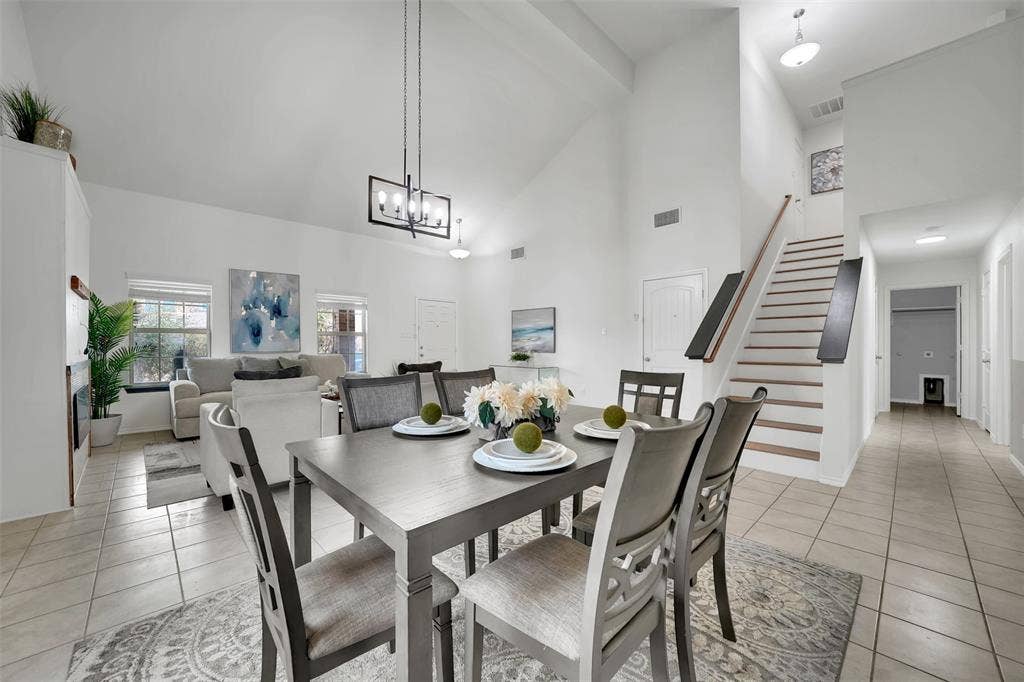 1121 Basswood Lane, Royse City, TX 75189 Dining area with light tile patterned floors, stairway, high vaulted ceiling, and visible vents