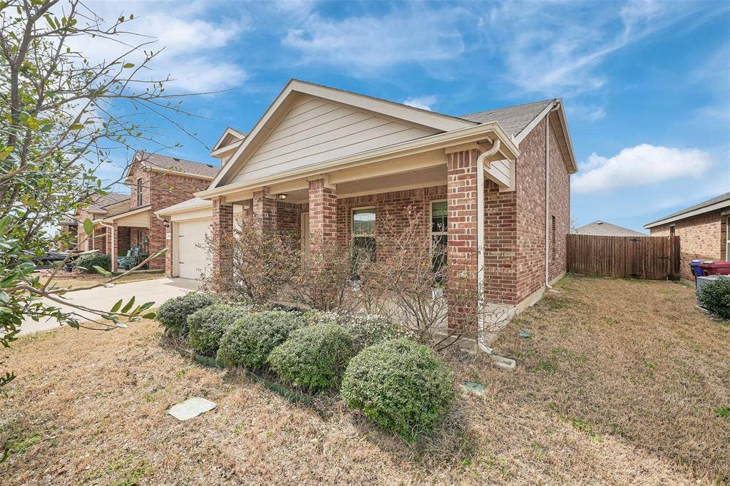 1121 Basswood Lane, Royse City, TX 75189 View of front of property with brick siding, fence, a front yard, a garage, and driveway