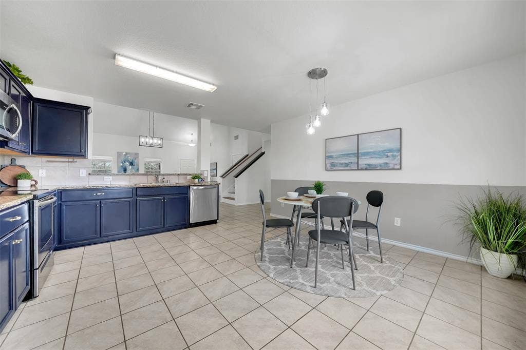 1121 Basswood Lane, Royse City, TX 75189 Kitchen featuring light tile patterned floors, blue cabinetry, stainless steel appliances, and a sink