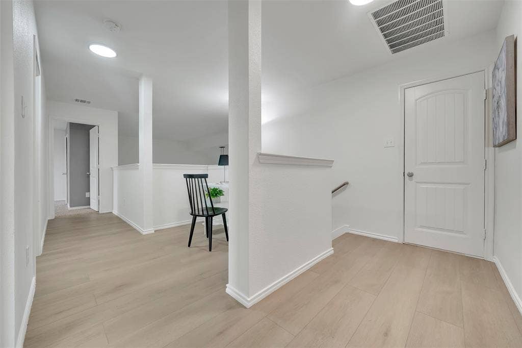 1121 Basswood Lane, Royse City, TX 75189 Corridor with light wood-type flooring, visible vents, an upstairs landing, and baseboards