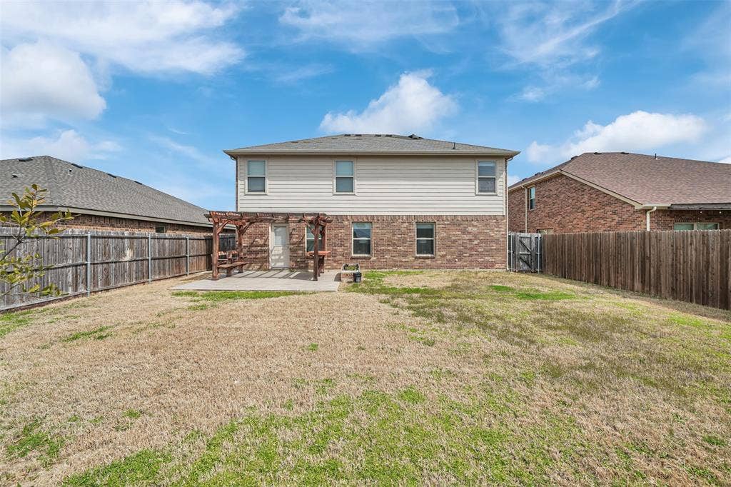 1121 Basswood Lane, Royse City, TX 75189 Rear view of property with a yard, a fenced backyard, a pergola, a patio area, and brick siding