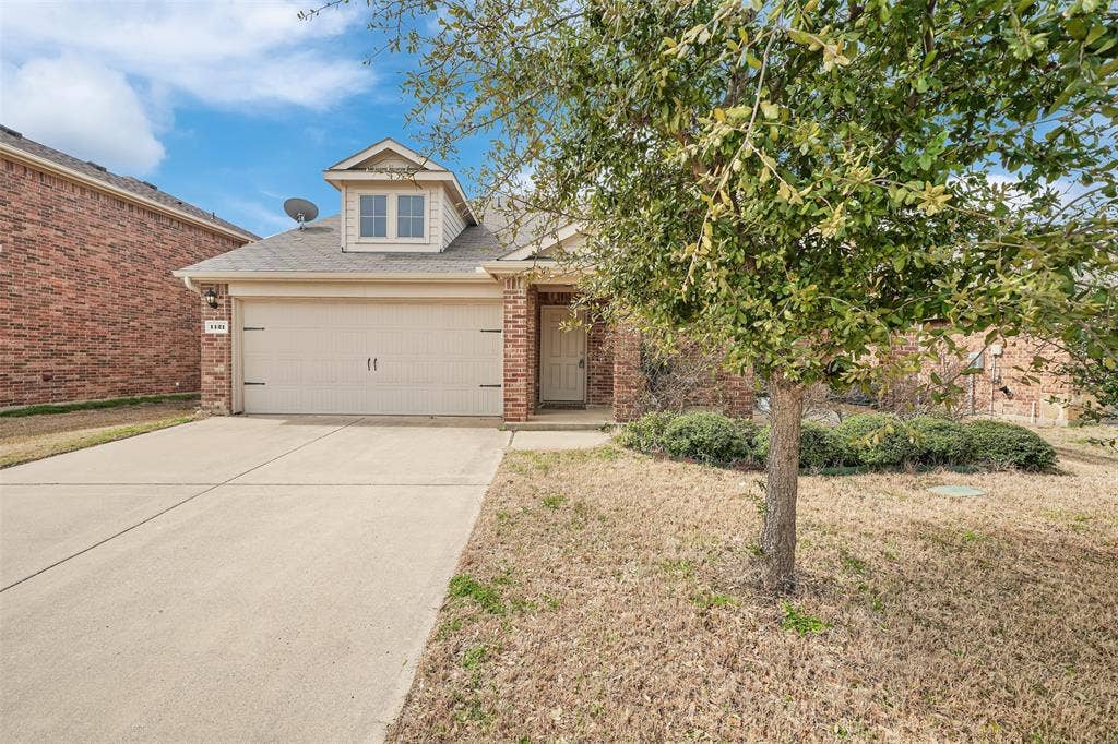 1121 Basswood Lane, Royse City, TX 75189 View of front of home featuring a garage, a front lawn, brick siding, and driveway