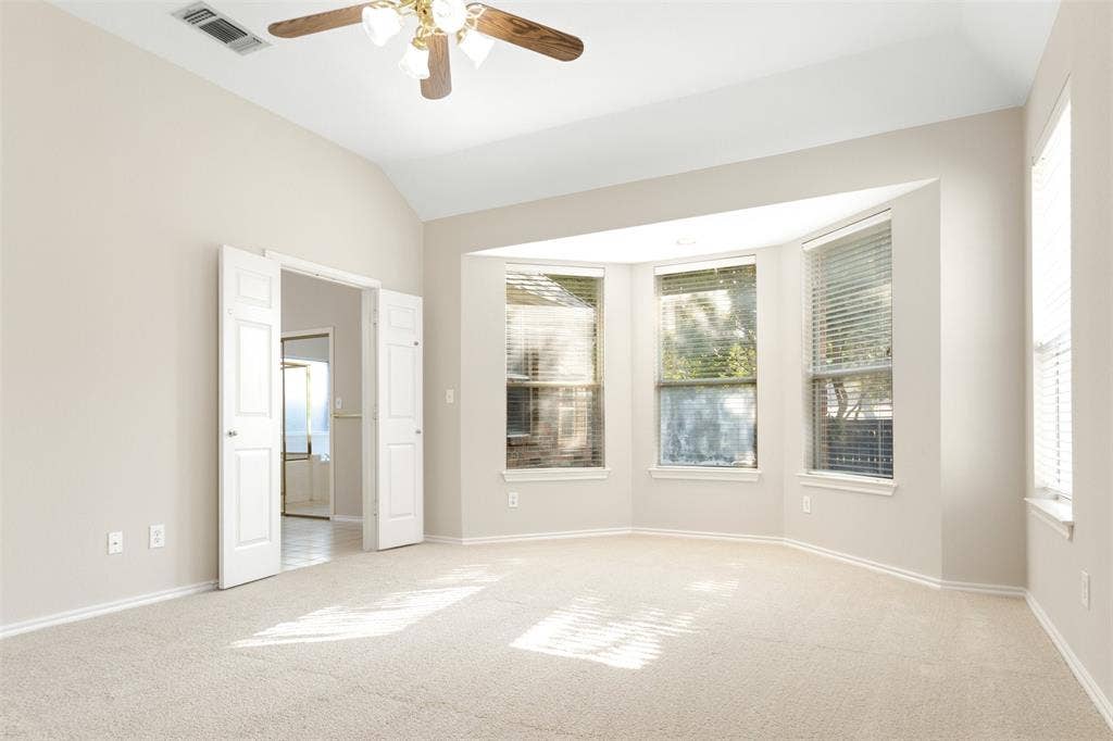 2803 Pheasant Run Drive, McKinney, TX 75072 Vaulted ceilings featuring a central ceiling fan with integrated lighting, expansive bay window, and neutral wall-to-wall carpeting