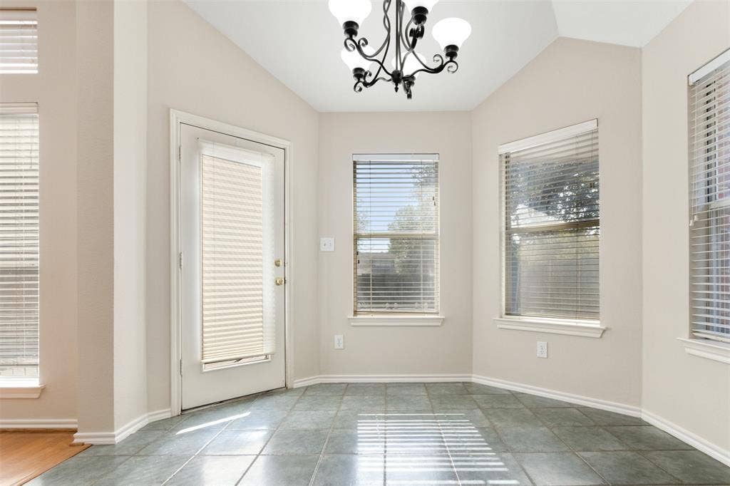 2803 Pheasant Run Drive, McKinney, TX 75072 Vaulted ceiling featuring a wrought iron chandelier, ceramic tile flooring, and multiple windows with integrated blinds