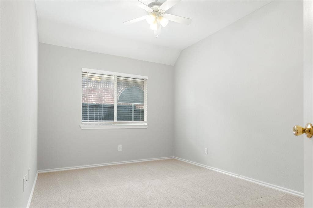 2803 Pheasant Run Drive, McKinney, TX 75072 Neutral-toned room featuring a vaulted ceiling, neutral wall-to-wall carpeting, a multi-light ceiling fan, and a single-pane window