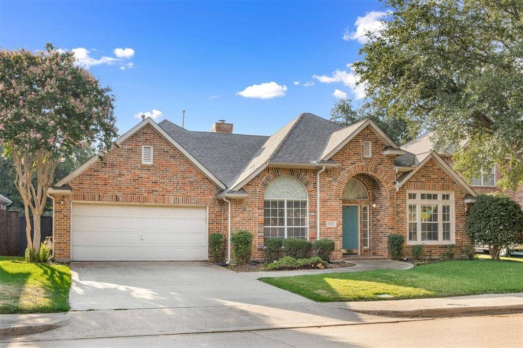 2803 Pheasant Run Drive, McKinney, TX 75072 Traditional brick exterior featuring an arched entryway, multiple gabled rooflines, divided-lite windows with arched upper accents, and an attached two-car garage
