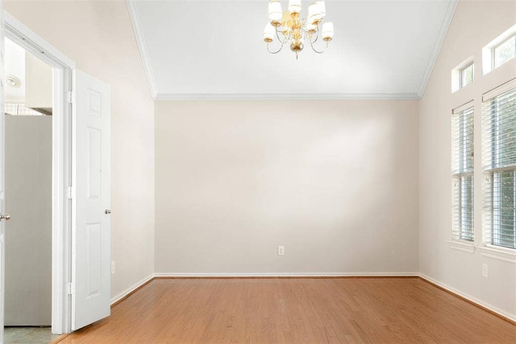 2803 Pheasant Run Drive, McKinney, TX 75072 Vaulted ceiling with crown molding, wood-finish flooring, multi-pane windows with horizontal blinds, and a multi-arm metallic chandelier