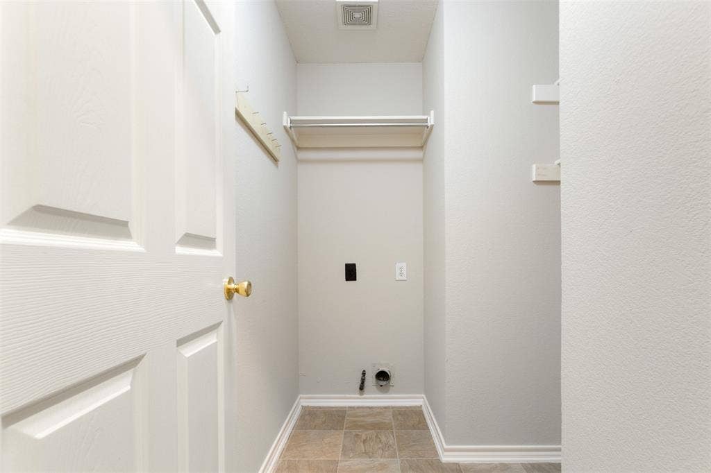 2803 Pheasant Run Drive, McKinney, TX 75072 Utility space featuring tile flooring, built-in shelving, wall-mounted racks, and dedicated hookups