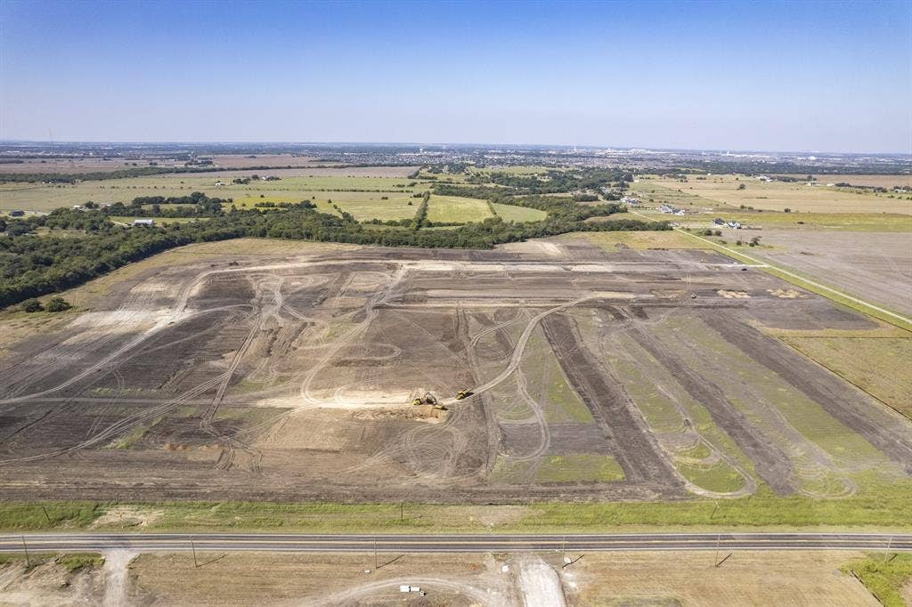 Expansive acreage featuring cleared land, topographical variety, and direct frontage to a paved roadway