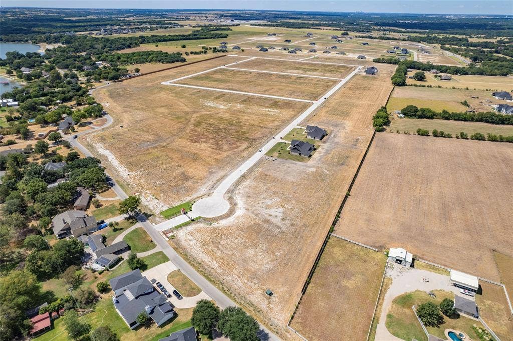 Expansive undeveloped acreage featuring paved street infrastructure, cul-de-sac access, utility access points, and proximity to open water