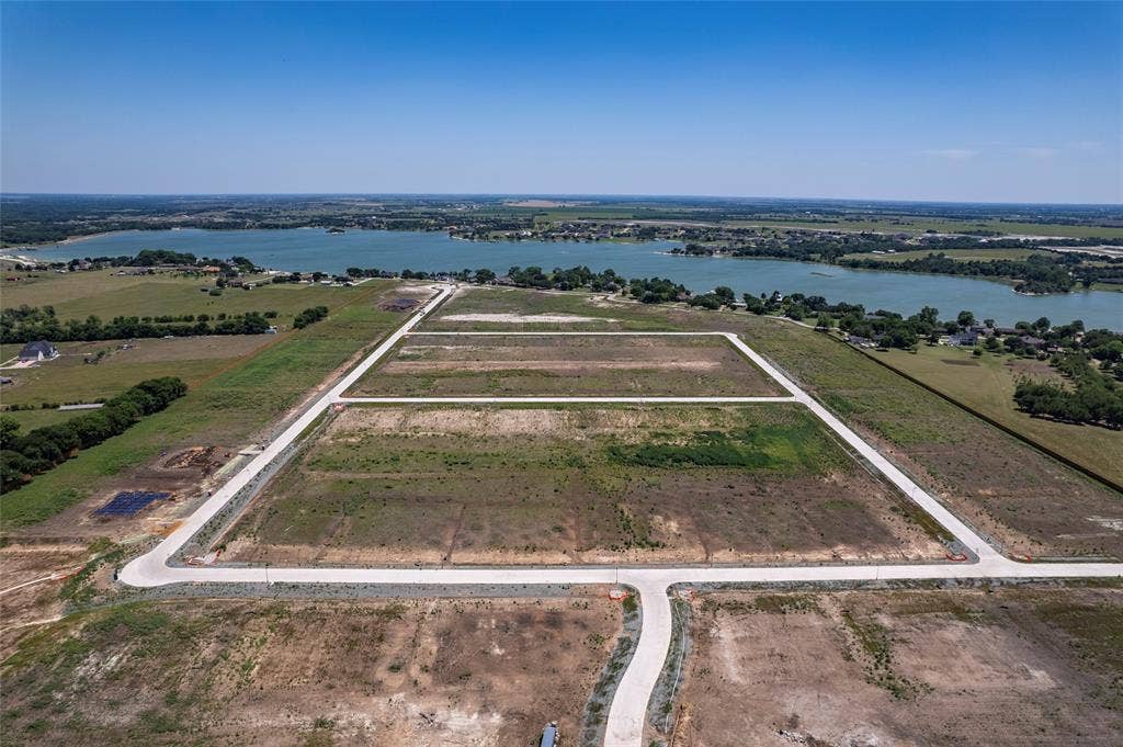 Expansive land parcel featuring paved street infrastructure and direct proximity to a large reservoir