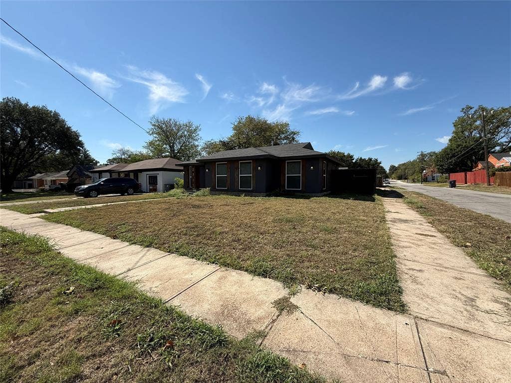 2703 Downing Avenue, Dallas, TX 75216 Single-story residence featuring a dark-toned exterior finish, low-pitch roofline, and rectangular window framing