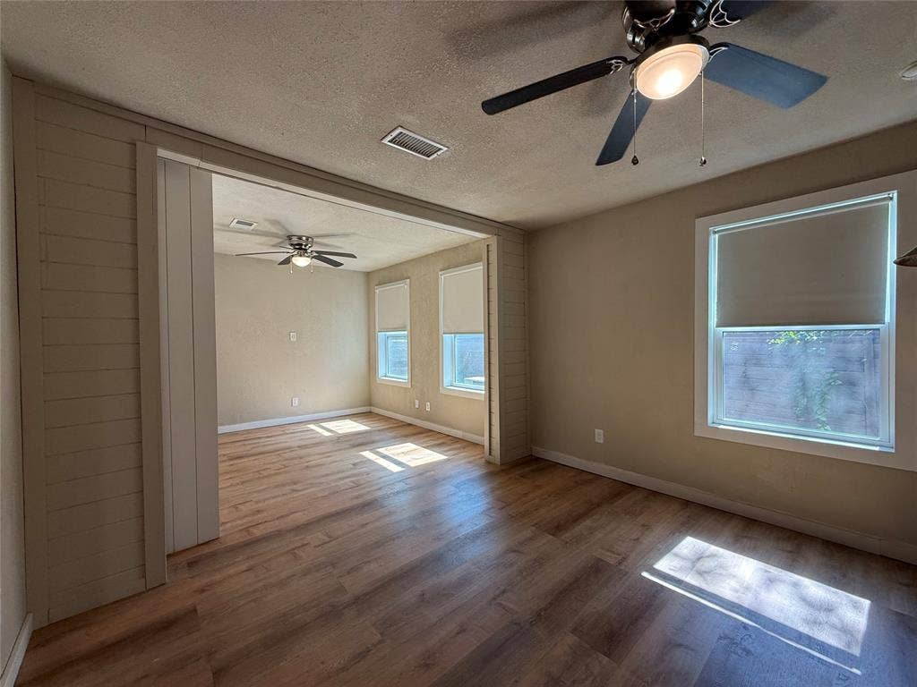 2703 Downing Avenue, Dallas, TX 75216 Wood-finish flooring, paneled wall detailing, and dual ceiling fans with integrated lighting fixtures