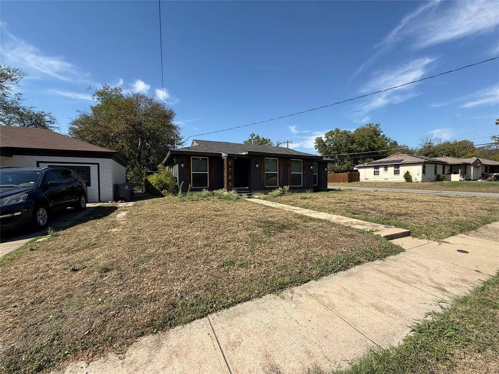 2703 Downing Avenue, Dallas, TX 75216 Single-story exterior featuring dark-toned horizontal siding, a gabled roofline, and a recessed entryway