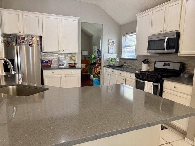 11159 Covey Lane, Frisco, TX 75035 Kitchen featuring white shaker-style cabinetry, solid-surface countertops, a stainless steel refrigerator, a built-in microwave, and a tiled backsplash