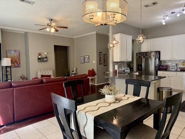 11159 Covey Lane, Frisco, TX 75035 Open-concept interior featuring white cabinetry, a kitchen island with stone-surface countertop, drum-style ceiling light fixtures, and tiled flooring