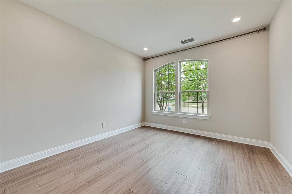 9829 Sharps Drive, Frisco, TX 75035 Room featuring wood-finish flooring, recessed lighting, and a multi-pane window with an arched transom