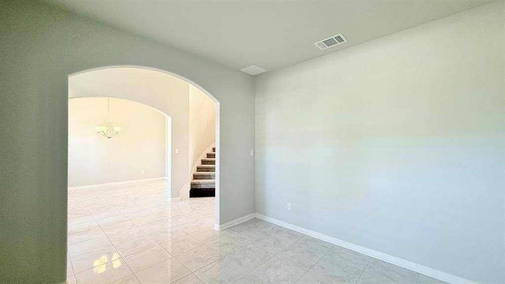 2937 Mossy Springs Drive, Leander, TX 78641 Interior featuring polished tile flooring, neutral wall tones, and a large architectural archway