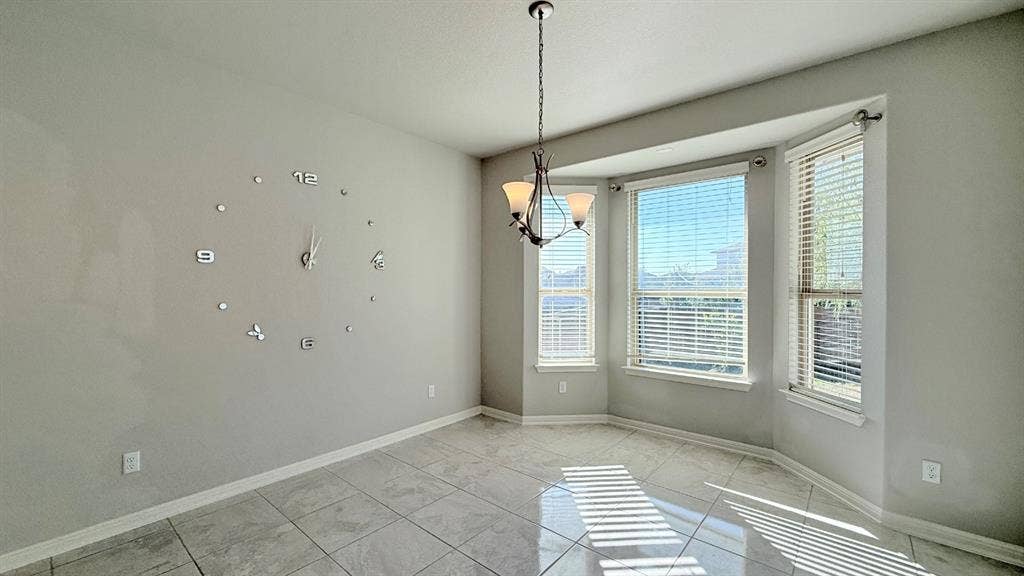2937 Mossy Springs Drive, Leander, TX 78641 Light-filled room featuring large-format ceramic tile flooring, a multi-pane bay window, and a decorative multi-arm chandelier