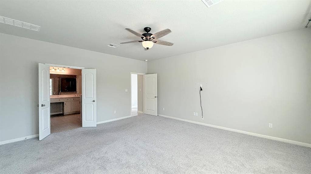 2937 Mossy Springs Drive, Leander, TX 78641 Neutral wall tones, carpeted flooring, multi-speed ceiling fan with integrated lighting, and interior doors with panel detailing