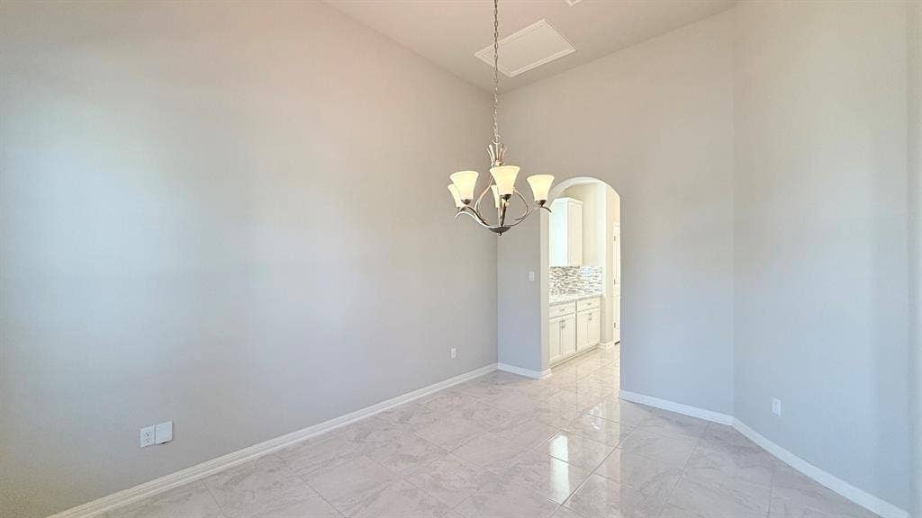 2937 Mossy Springs Drive, Leander, TX 78641 High ceilings, polished stone-finish tile flooring, arched entryway, and multi-arm chandelier