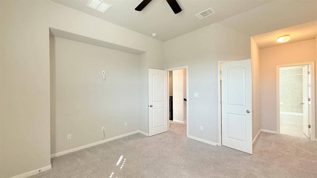 2937 Mossy Springs Drive, Leander, TX 78641 Vaulted ceilings featuring a black ceiling fan, recessed wall alcove, neutral wall color, and wall-to-wall carpeting