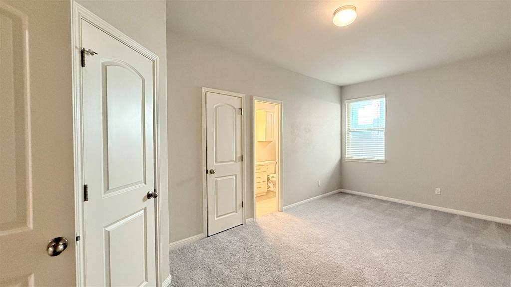2937 Mossy Springs Drive, Leander, TX 78641 Neutral interior featuring wall-to-wall carpeting, two-panel interior doors, and a window with horizontal blinds