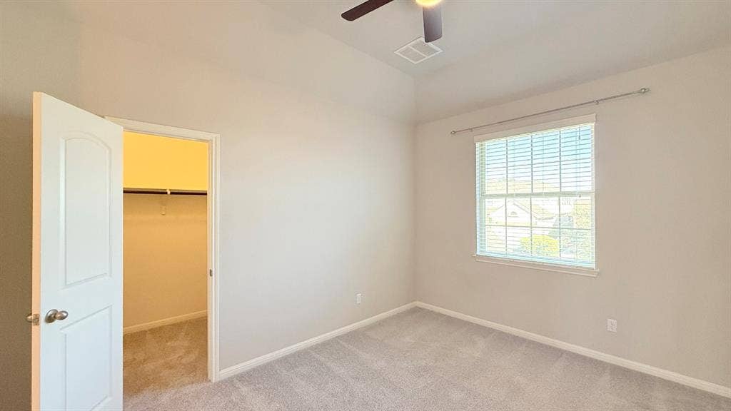 2937 Mossy Springs Drive, Leander, TX 78641 Room featuring high ceilings, wall-to-wall carpeting, a ceiling fan, and a walk-in closet