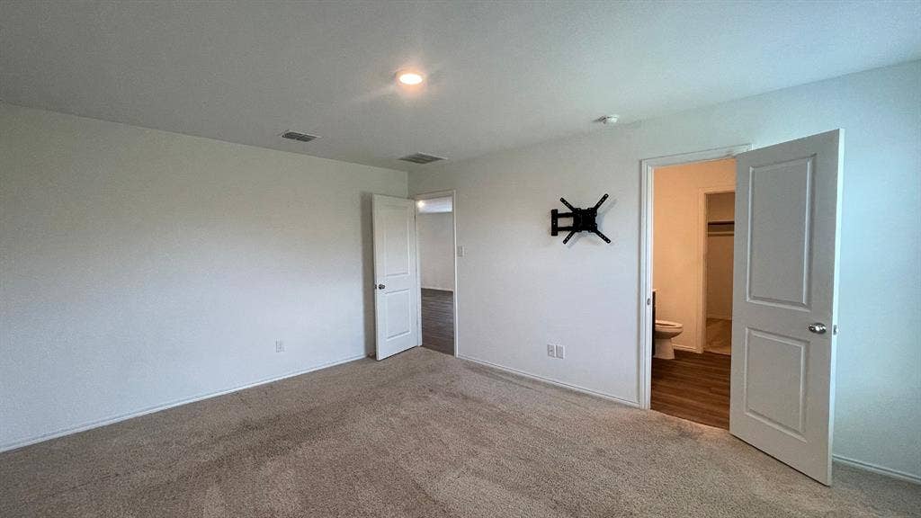 Neutral interior space featuring carpeted flooring, two-panel interior doors, and recessed lighting