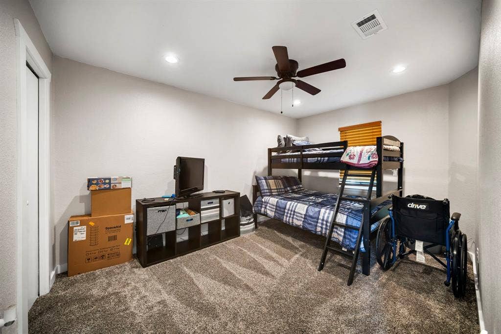 205 Newman Road, Ennis, TX 75119 Neutral-toned room featuring textured wall-to-wall carpeting, recessed ceiling lighting, and a dark-finish ceiling fan