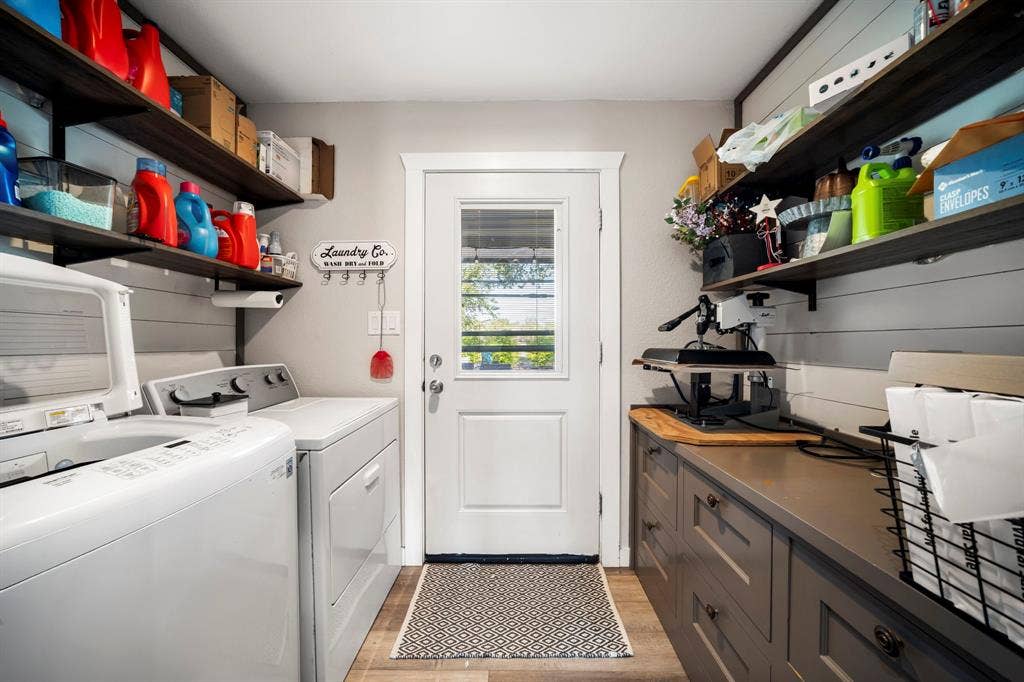 205 Newman Road, Ennis, TX 75119 Laundry room featuring shiplap wall paneling, custom gray base cabinetry with a solid surface countertop, open dark wood shelving, and wood-finish flooring