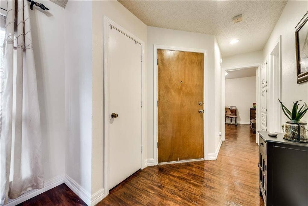 3702 Pulsar Drive, Garland, TX 75044 Entryway featuring wood-finish flooring, a solid wood entry door, a recessed ceiling light, and white interior doors