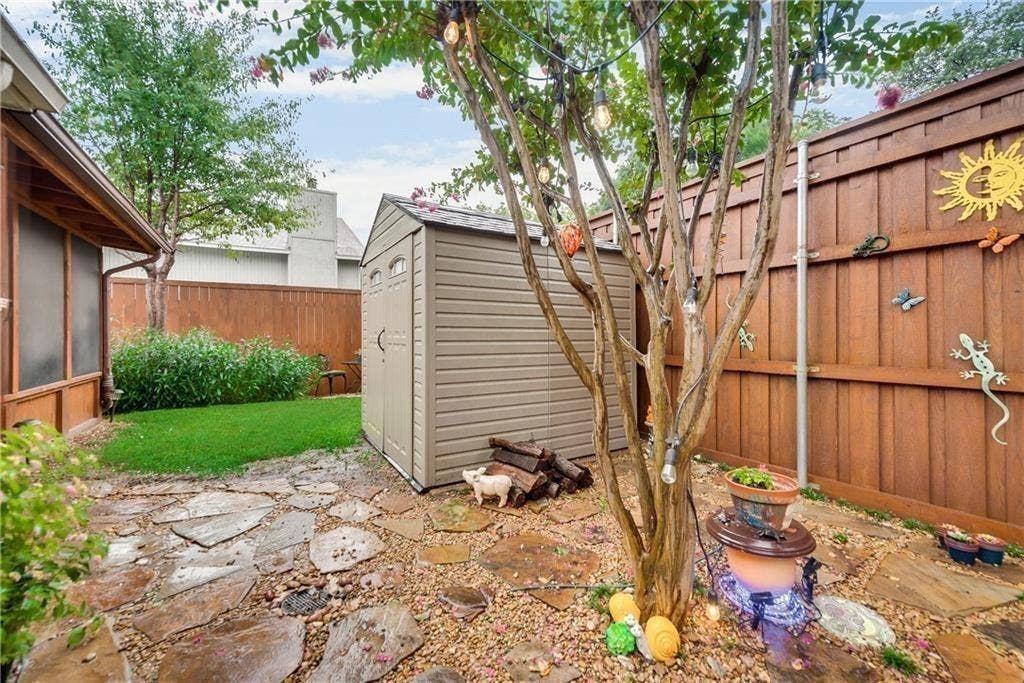 3702 Pulsar Drive, Garland, TX 75044 Rear yard featuring a flagstone patio, lawn area, storage shed, and full-height wood privacy fencing