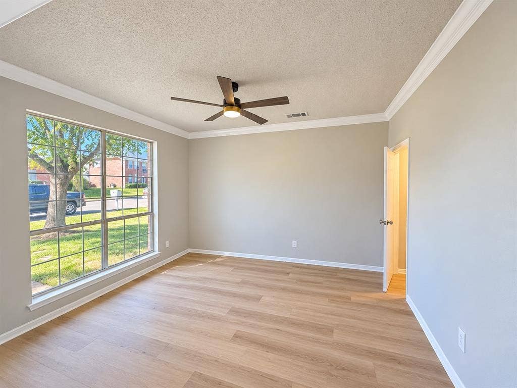 1412 Kaylor Drive, DeSoto, TX 75115 Wood-finish flooring, crown molding, a large picture window, and a ceiling fan with integrated lighting