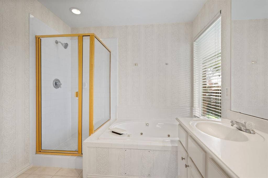 Full bathroom with a stall shower, vanity, a whirlpool tub, wallpapered walls, and tile patterned flooring