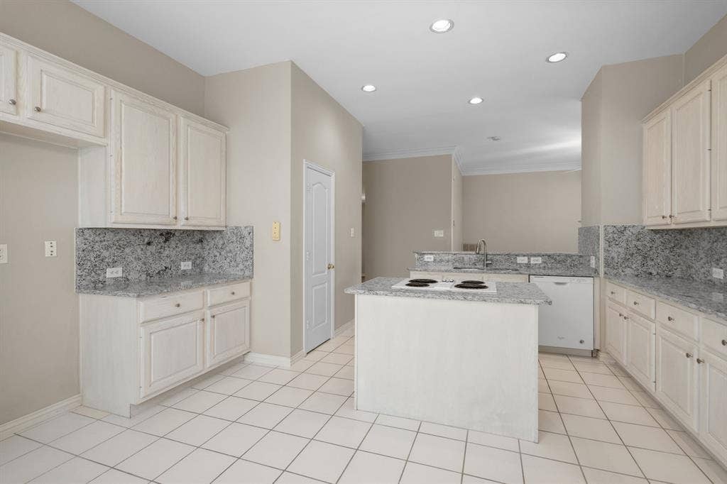 Kitchen with white appliances, decorative backsplash, recessed lighting, a peninsula, and light stone counters