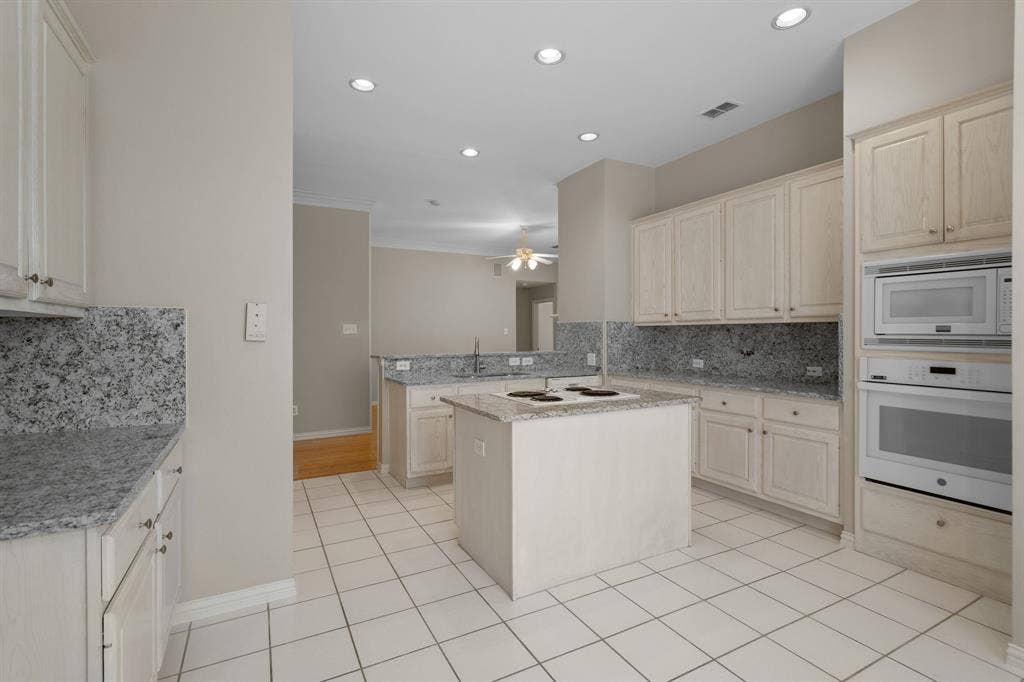 Kitchen with white appliances, a ceiling fan, tasteful backsplash, recessed lighting, and a peninsula