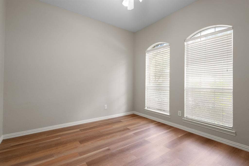 Empty room featuring light wood-type flooring and ceiling fan